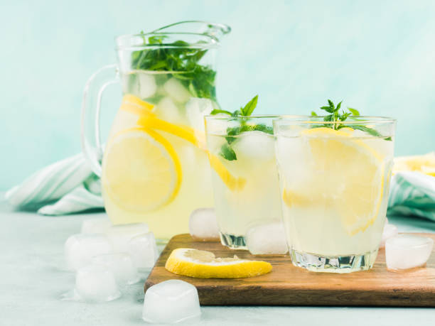 frische zitronenlimonade in krug und gläser - glass ice tonic water frozen stock-fotos und bilder