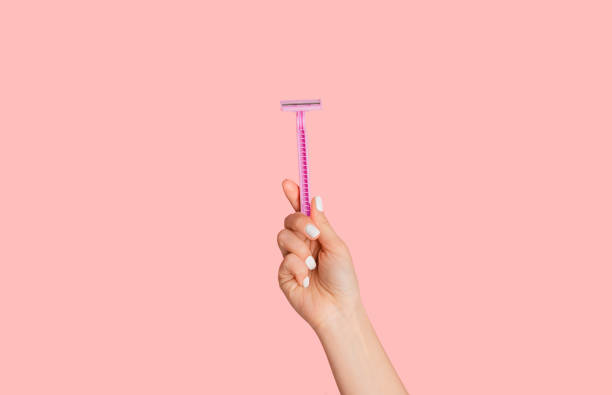 Young girl showing disposable razor on pink background, closeup of hand Young girl showing disposable razor on pink background, close up of hand shaving stock pictures, royalty-free photos & images