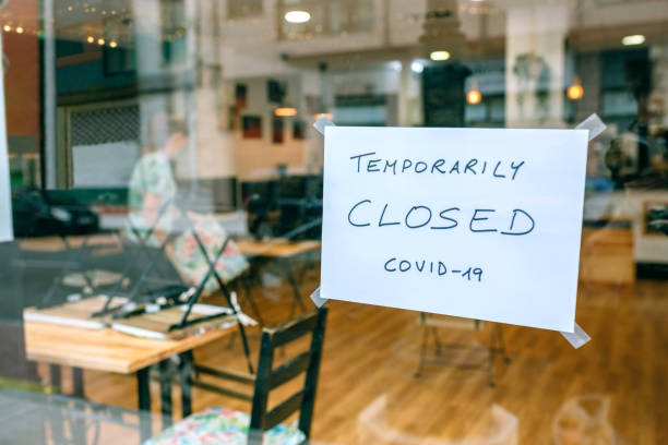 Coffee shop closed by covid-19 Coffee shop closed by covid-19 with workers picking up and cleaning inside closed stock pictures, royalty-free photos & images