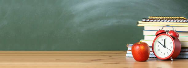 istock Alarm clock and textbooks on the school desk 1262873162