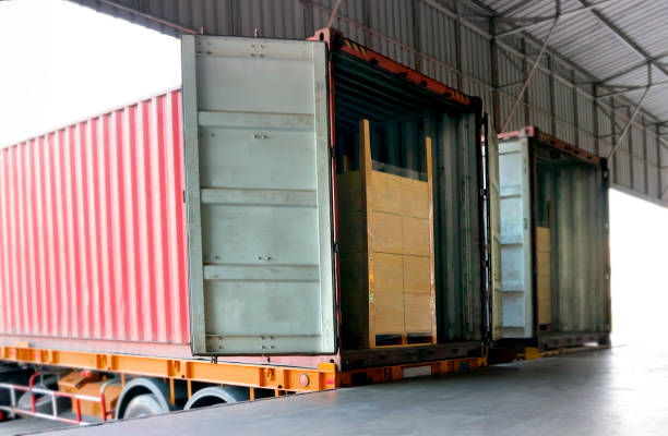 istock Cargo freight, Shipment, Delivery service. Logistics and transportation. Warehouse dock load pallet goods into shipping container truck. Stacked package boxes on pallet inside a truck. 1262874223