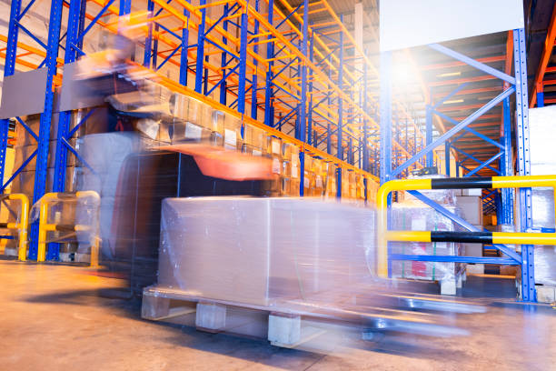 istock Blurred motion of forklift driver unloading shipment pallet goods in the warehouse storage. 1262874242