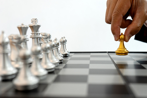Business people are thinking about chessboard chess gold and silver are on the table.