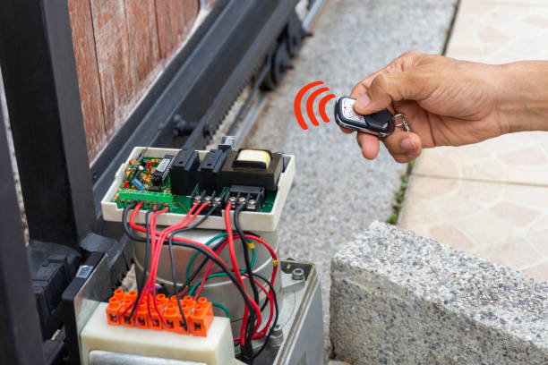 Maintenance and repairing automatic gate Technician man hand using remote control, testing and checking the functional of auto door. Maintenance and repairing automatic gate concept. service concept. automatic garage door stock pictures, royalty-free photos & images
