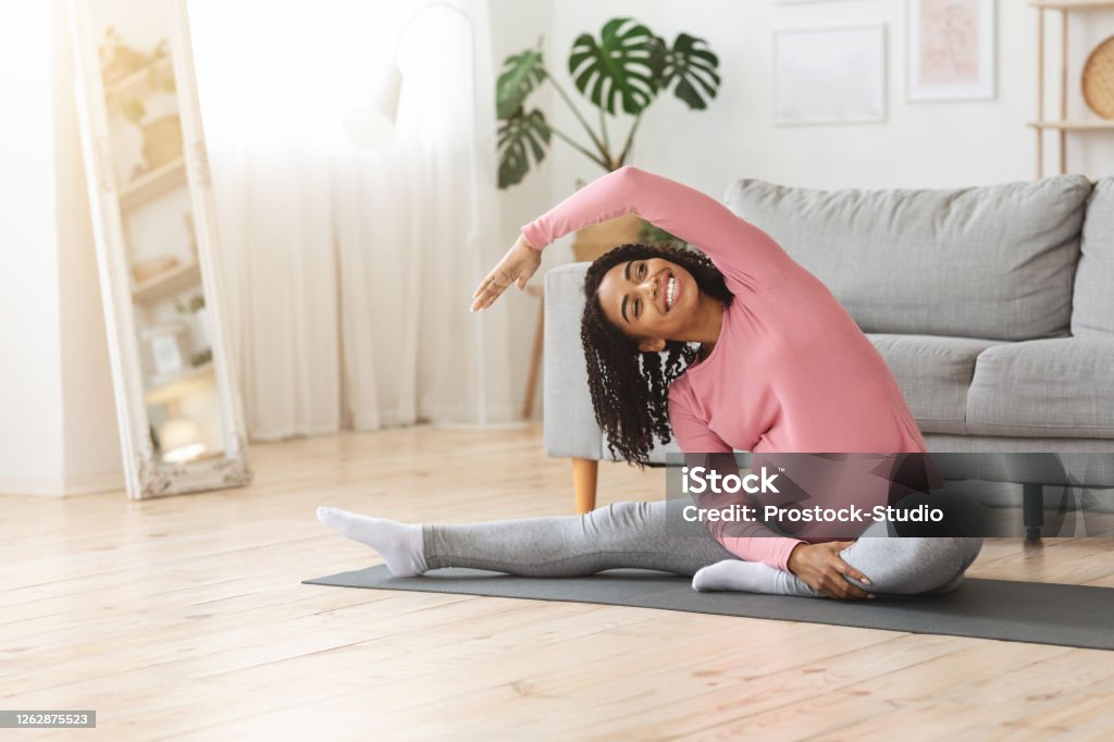 Positive african pregnant woman doing morning exercise at home Positive african american pregnant woman doing morning exercise at home, empty space Pregnant Stock Photo