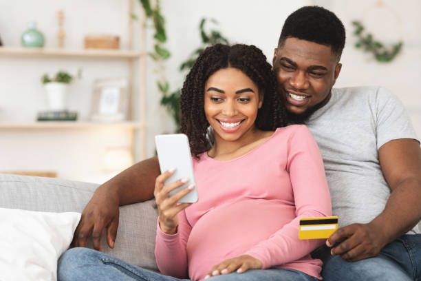 istock Happy pregnant couple using mobile application for shopping 1262875589
