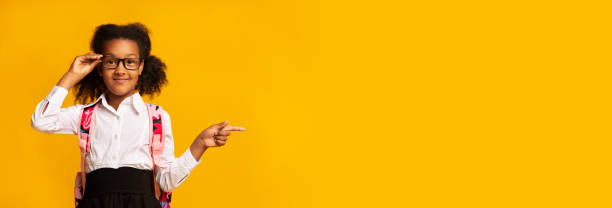 istock Adorable Black Schoolgirl Pointing Finger Aside, Studio, Panorama 1262875646