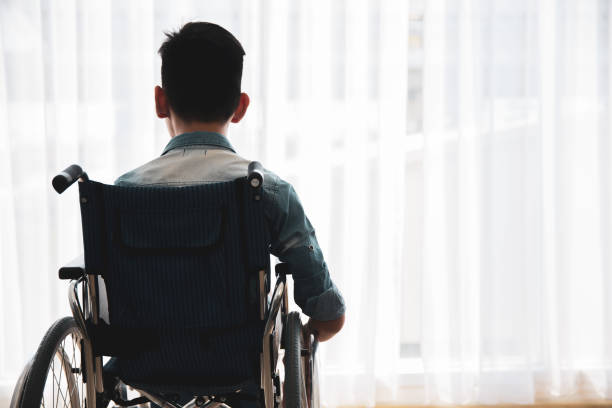 istock Disabled pateint back sitting on wheel chair looking out side with hope 1262877430
