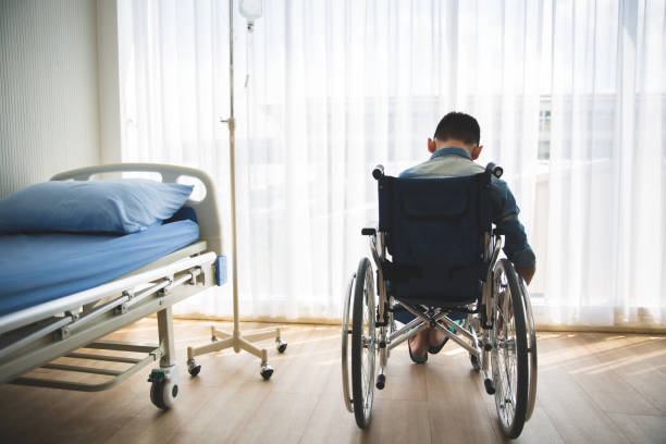 istock Disabled pateint back sitting on wheel chair looking out side with hope 1262877469