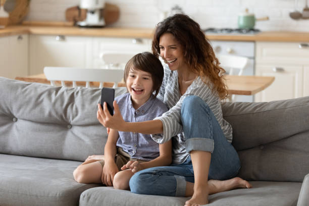 istock Joyful young woman taking selfie shot with son. 1262881713