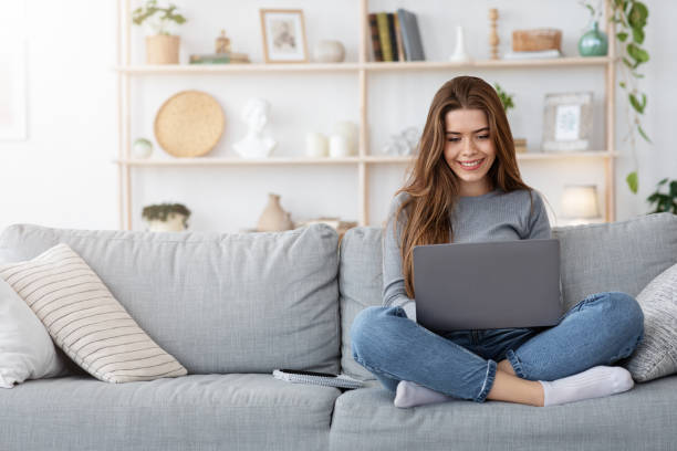 istock Smiling young woman working from home, using laptop 1262883326