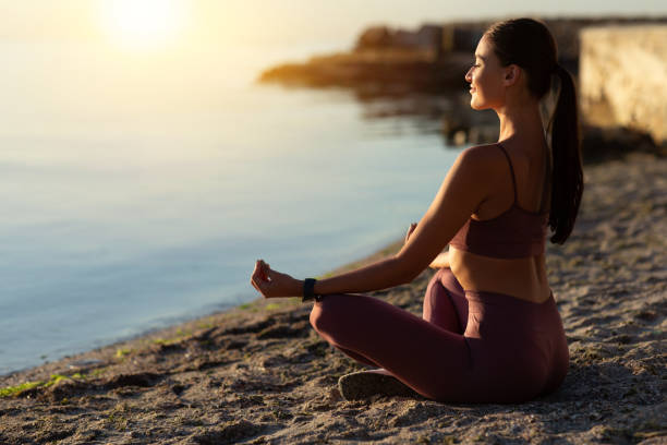 istock Female yogi sitting in lotus pose and meditating 1262887389