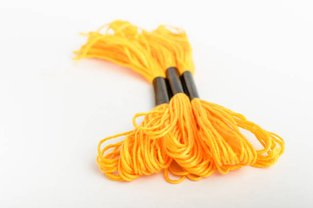 istock Three vivid yellow sewing threads for embroidery isolated on a white table, top view or flat lay of textile materials 1262889022