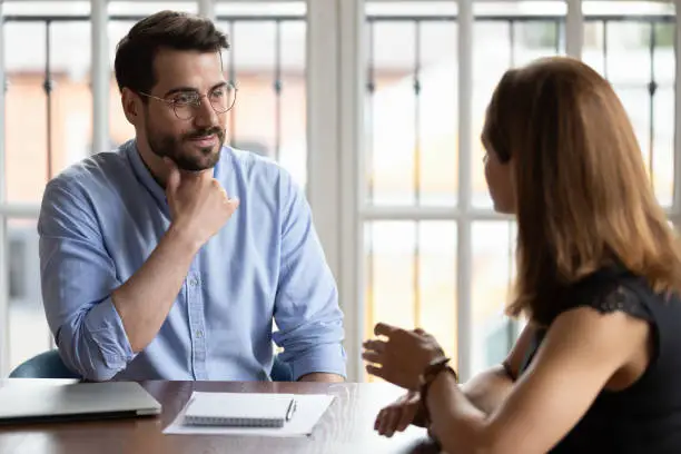 Photo of HR manger listening female applicant during job interview