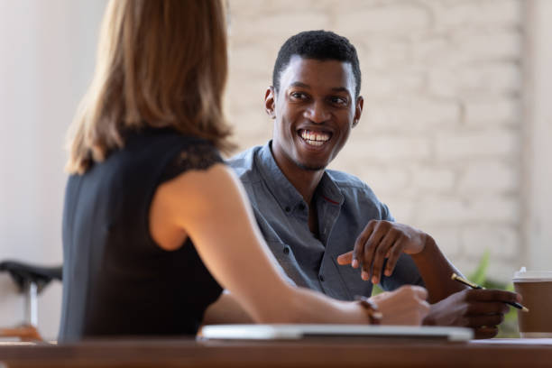 istock Multi-ethnic smiling teammates working together sitting at desk 1262889196