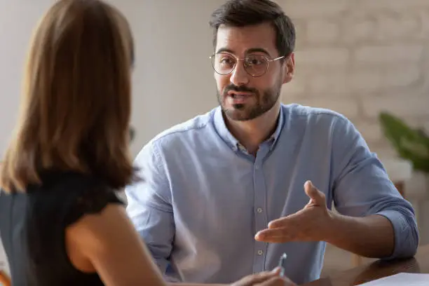 Photo of Confident caucasian male applicant answering on questions during job interview