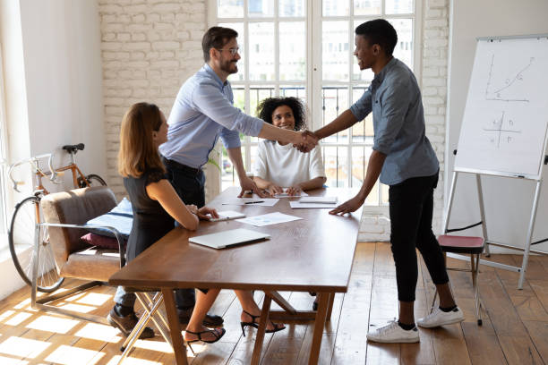 istock Caucasian boss and african client shake hands ending successful negotiations 1262889206