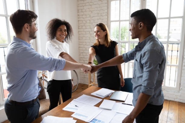 istock Diverse associates putting fists together showing amity and support 1262889231