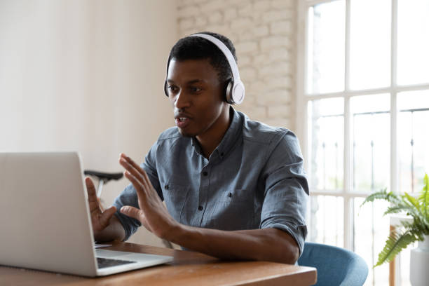 istock African manager looking at laptop screen talking to client distantly 1262889294