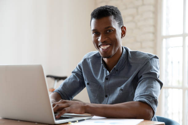 istock Smiling African businessman working sitting at workplace smile for camera 1262889303