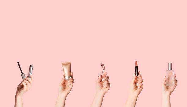 istock Women hands holding various cosmetic products on pink background, empty space. Creative collage 1262891315