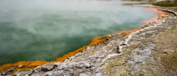 Photo of Steam rising up from the active geothermal area of Wai-O-Tapu in New Zealand