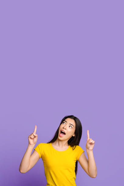 istock Interesting Offer. Excited Asian Girl Pointing At Copy Space Above Her Head 1262893202