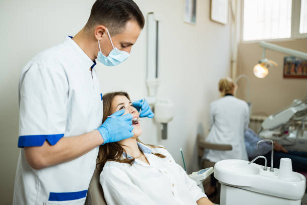 istock Young man dentist examining patients teeth in the office 1262893343