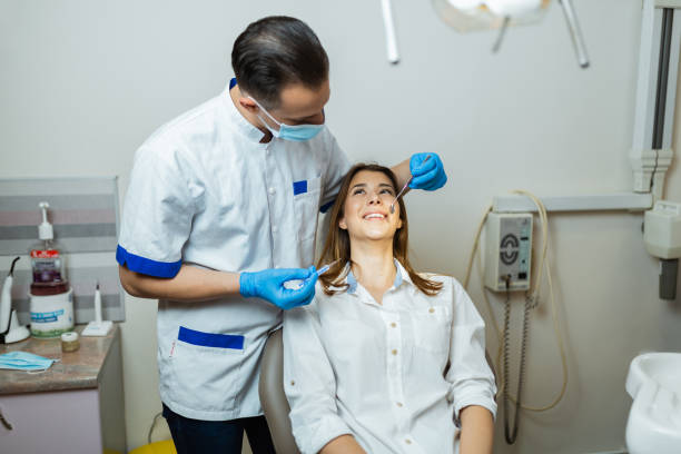 istock Young man dentist examining patients teeth in the office 1262893347