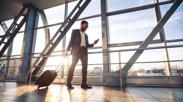 istock Man Using Phone And Business App Walking To Airport Gate 1262893432
