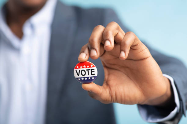 elezioni usa novembre 2020 pulsante patriottico in mano maschile - voting election badge straight pin foto e immagini stock