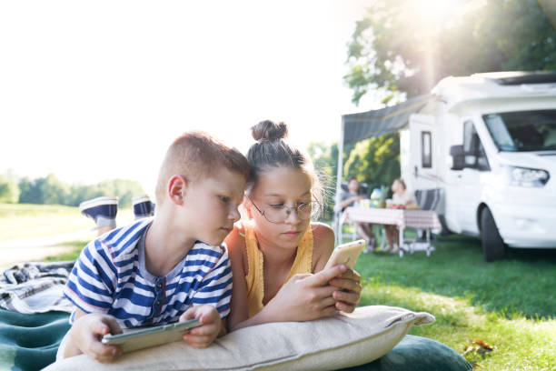 istock Children using mobile phone on camping holiday 1262896911
