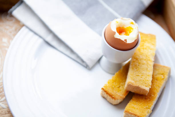 istock Soft boiled egg and soldiers on a white plate with copy space 1262897188