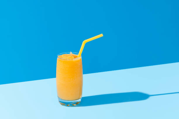mango smoothie on blue color. summer drink. mango shake with a straw - cocktail drinking straw ice glass imagens e fotografias de stock