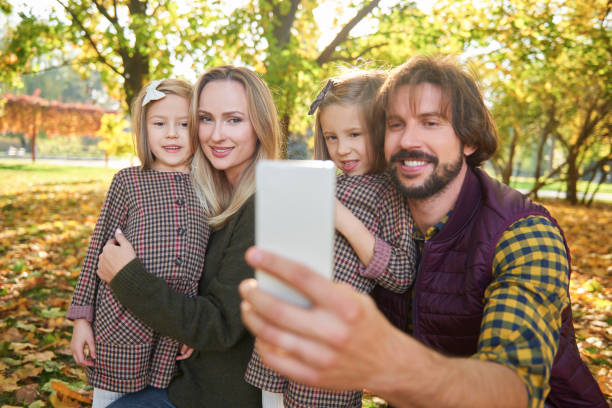 istock Happy family making a selfie in autumn forest 1262901933