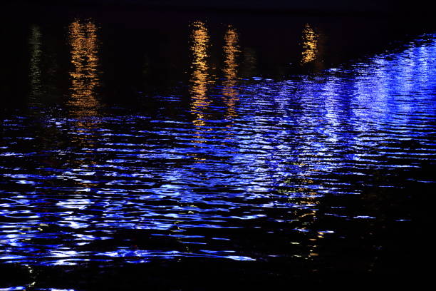 This dramatic moon rise in a deep blue night time sky is accented by highlighted clouds and beautiful, calm lake reflection.