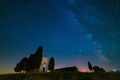 Night shot of the milky way over Vitaleta Chapel in Val d'Orcia, Siena Province, Tuscany. Madonna di Vitaleta chapel is a famous spot in Italy.