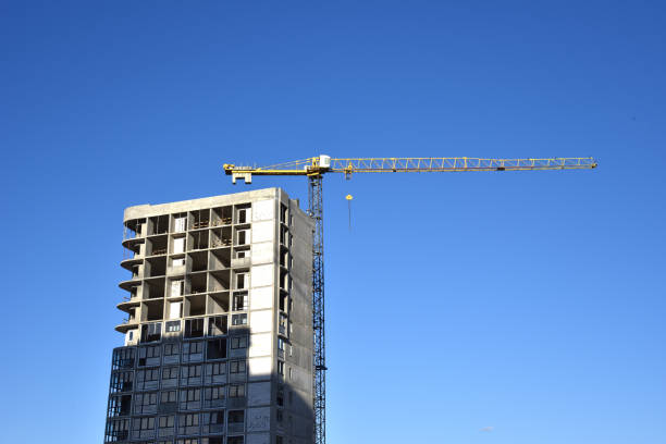 istock Tower cranes working at construction site on blue sky background. Construction process of the new modern residential buildings. 1262906837