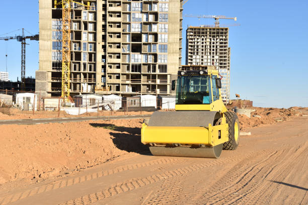 istock Vibro Roller Soil Compactor leveling soil at construction site. Excavator and vibration single-cylinder road roller during the construction of road 1262906900