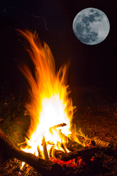 istock closeup camp fire under a huge moon, outdoor night scene 1262907156