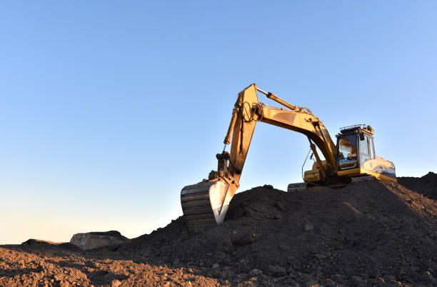 istock Excavator working on earthmoving at open pit mining. Yellow Backhoe digs sand and gravel in quarry. 1262907291