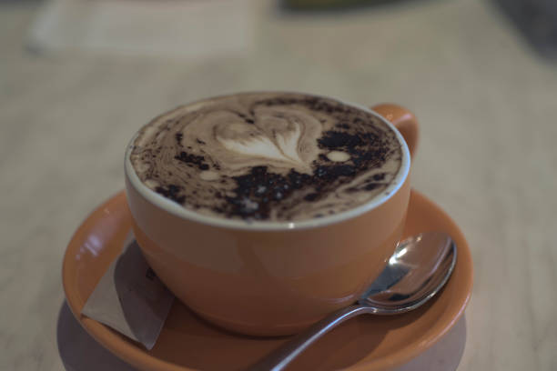 istock Coffee cup with cappuccino, love heart pattern, faded colour. 1262909562
