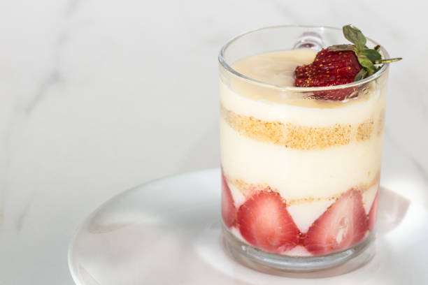 jar of strawberry pudding magnolia desert over white backdrop