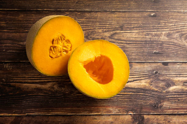 istock Sliced fresh Cantaloupe on a Wood Plank Board Background 1262924057