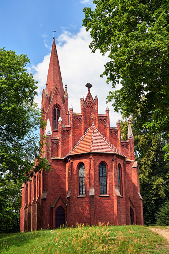 The tower of the historic, neo-Gothic red brick church in the village of Chycina in Poland