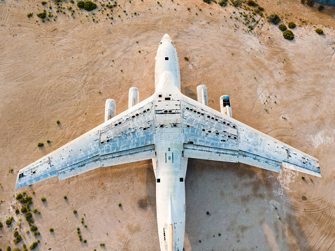 Abandoned airplane by the highway in the desert of Umm Al Quwain emirate of the United Arab Emirates aerial closeup view at sunrise