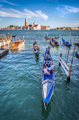 Venice, Italy – August 13, 2017: Gondola full of people with San Giorgio Maggiore island on the background