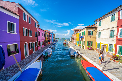 Burano, Italy - August 14, 2017: Tourists in the streets and canal of Colorful city of Burano