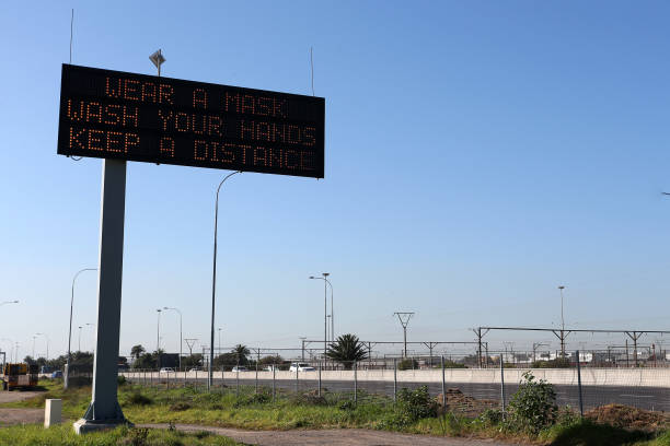 un mensaje de prevención de covid-19 en una señal de carretera electrónica - copy space road sign sky above fotografías e imágenes de stock