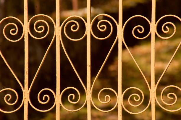 Retro styled cast iron decorated yellow fence, landscape in the background, Galicia, Spain.